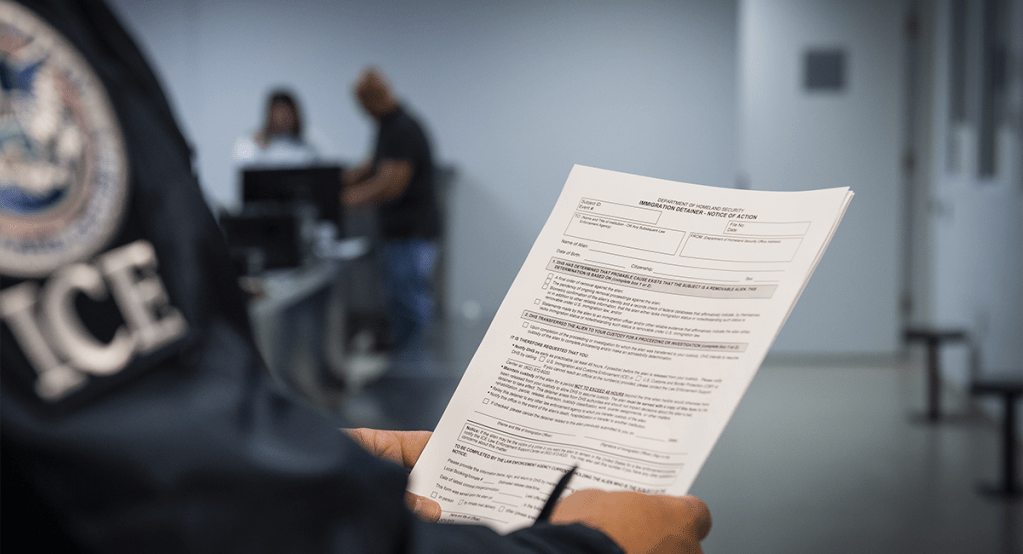 Agente de ICE sosteniendo un documento oficial